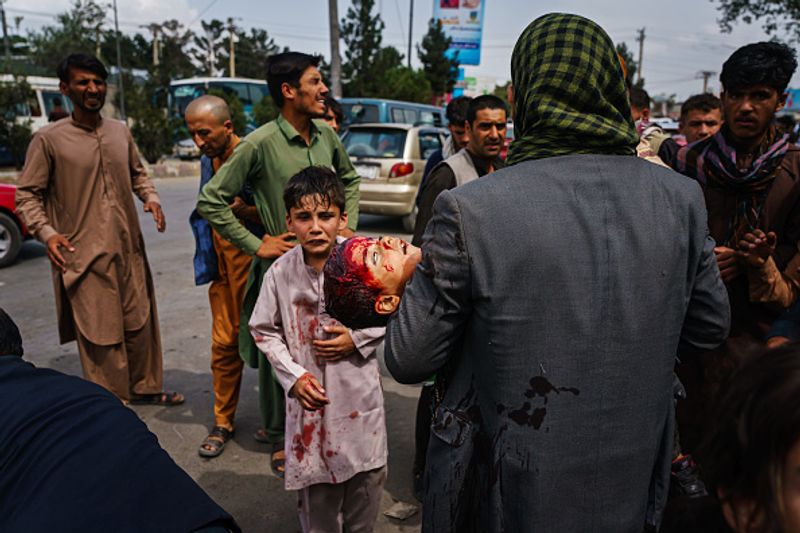 iconic photo baby lifted over wall at Kabul airport by Marine