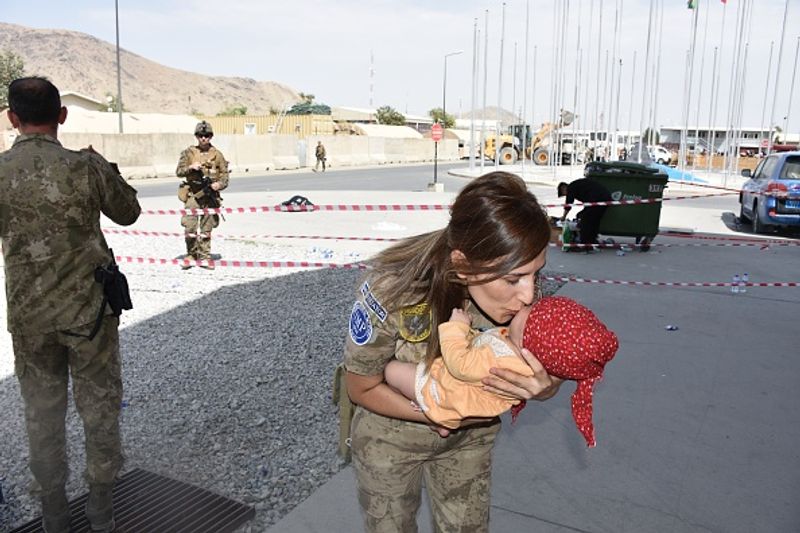 iconic photo baby lifted over wall at Kabul airport by Marine