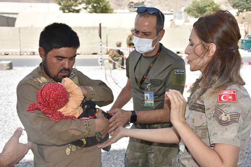 iconic photo baby lifted over wall at Kabul airport by Marine