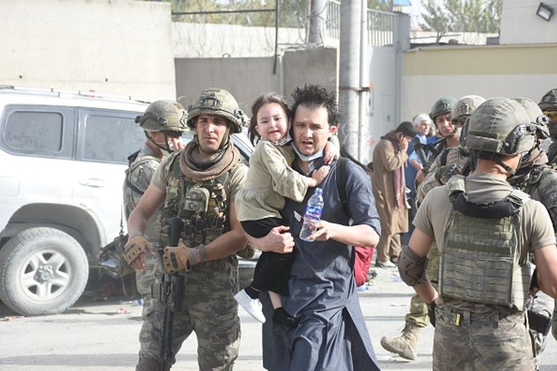 iconic photo baby lifted over wall at Kabul airport by Marine