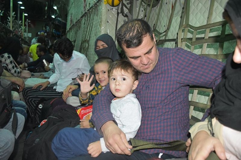 iconic photo baby lifted over wall at Kabul airport by Marine