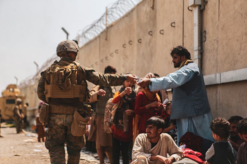iconic photo baby lifted over wall at Kabul airport by Marine