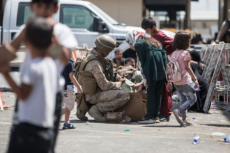 iconic photo baby lifted over wall at Kabul airport by Marine