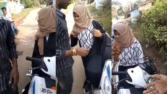 woman riding pillion on a scooter was forced to remove her hijab by some people in Bhopal woman riding pillion on a scooter was forced to remove her hijab by some people in Bhopal
