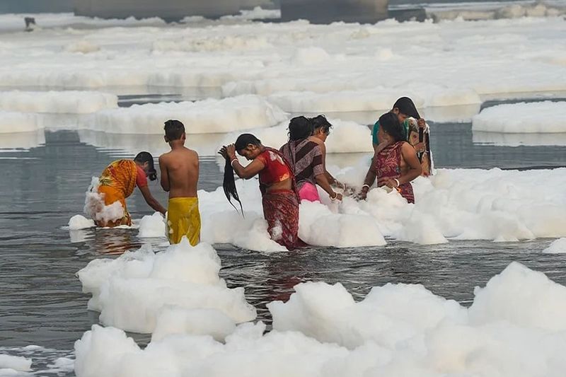 chhath puja 2021,delhi people tak dip in yamuna river toxic foam near kalindi kunj