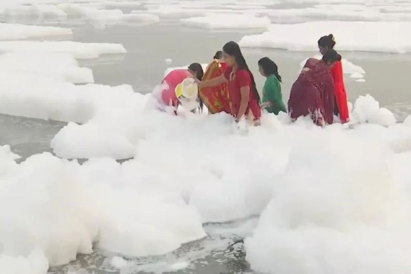 chhath puja 2021,delhi people tak dip in yamuna river toxic foam near kalindi kunj