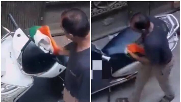 Man uses national flag to clean scooter video Man uses national flag to clean scooter video