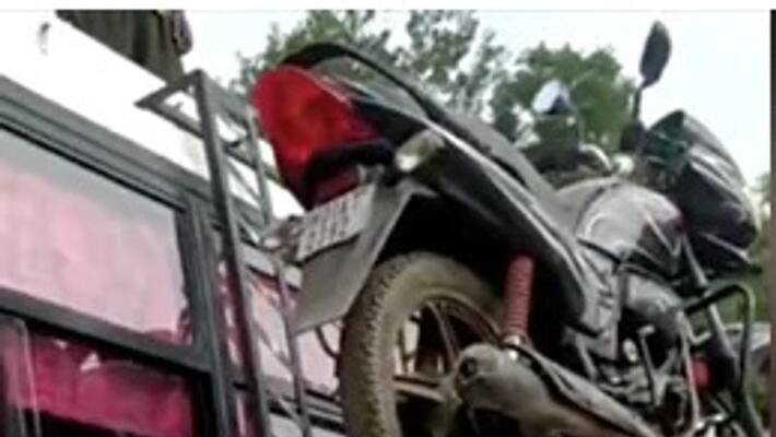 Man Climbs Bus Ladder With heavy Motorbike On His Head Video goes viral Man Climbs Bus Ladder With heavy Motorbike On His Head Video goes viral
