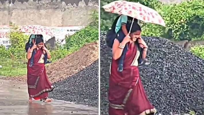 mother carrying her daughter on shoulders while walking in rain mother carrying her daughter on shoulders while walking in rain