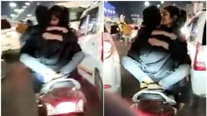 Couple seen romancing on two wheeler on city streets Couple seen romancing on two wheeler on city streets