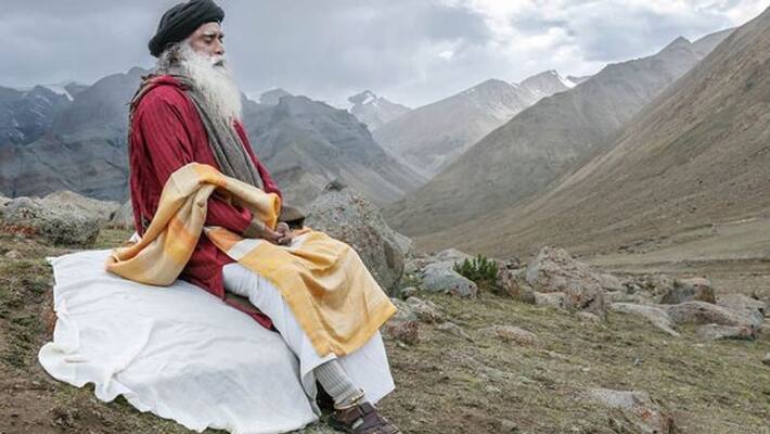 Download Sadhguru Standing On A White Hall Wallpaper | Wallpapers.com