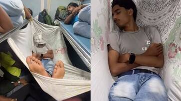 A man sleeping in fully rush train by cradle which made by bedsheet, video goes viral in social Media akb A man sleeping in fully rush train by cradle which made by bedsheet, video goes viral in social Media akb