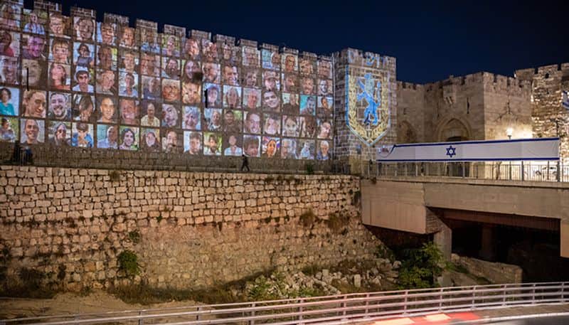 Faces of Israeli hostages projected on Jerusalem walls, candle-light vigil marks 1 month since Hamas attack snt
