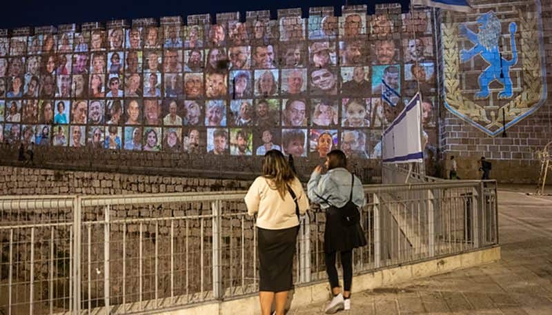 Faces of Israeli hostages projected on Jerusalem walls, candle-light vigil marks 1 month since Hamas attack snt