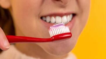 woman distracted by documentary brushes teeth with pain relief cream rlp woman distracted by documentary brushes teeth with pain relief cream rlp