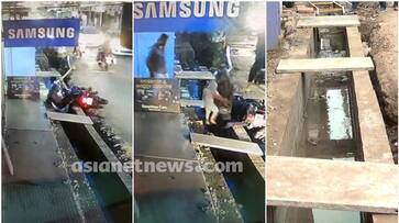 A family falls into open drain in Thrissur while traveling on a bike apn A family falls into open drain in Thrissur while traveling on a bike apn