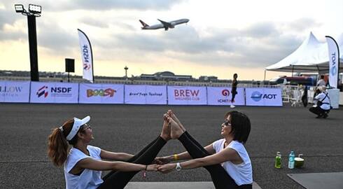 Yogis take flight! Hundreds of people perform yoga on runway of Bangkok's main airport (WATCH) snt